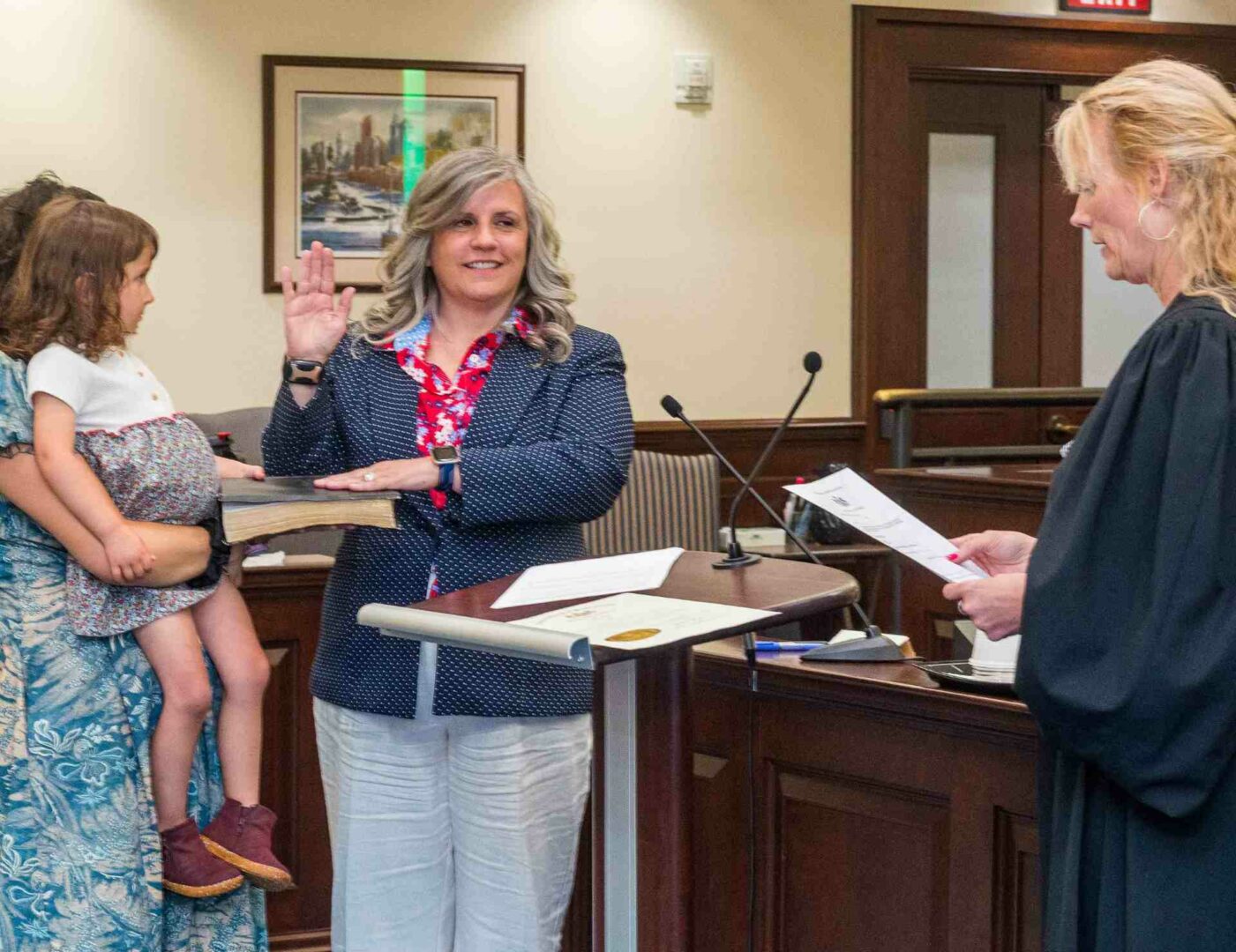 Jennifer Lopez is sworn in with her hand on a Bible and a Judge is present.